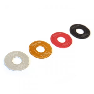 Può includere: Quattro manopole rotonde per chitarra con le parole "Rhythm" e "Treble" su di esse. Le manopole sono di diversi colori: argento, oro, rosso e nero.