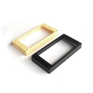 May include: Two guitar pickup rings, one black and one cream coloured. Both are made of plastic and have screw holes for mounting.