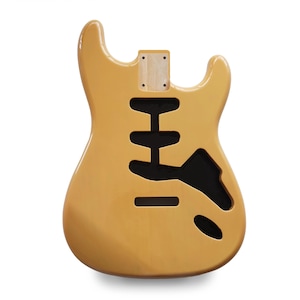 Könnte beinhalten: Ein hellbrauner Gitarrenkorpus mit schwarzen Aussparungen für Tonabnehmer und Bedienelemente. Der Korpus hat eine glatte, glänzende Oberfläche und ist für eine E-Gitarre mit massivem Korpus konzipiert. Die Halstasche ist oben sichtbar.