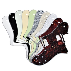 Könnte beinhalten: Ein Satz von zehn Gitarren-Pickguards in verschiedenen Farben und Mustern, darunter Schwarz, Weiß, Creme, Grün und Schildpatt.