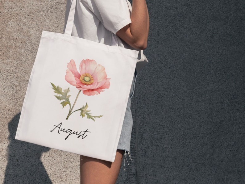 May include: White tote bag with a pink watercolor poppy flower and the word "August" printed on it.