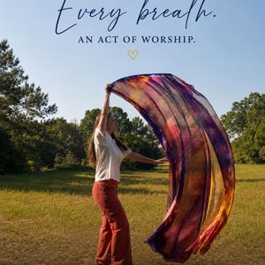 May include: A large, flowing worship flag featuring a vibrant, multi-colored gradient of purple, red, and gold. The text at the top reads: EVERY MOVEMENT. Every breath. AN ACT OF WORSHIP. The bottom text reads: YOU PREPARE A TABLE BEFORE ME IN THE PRESENCE OF MY ENEMIES. YOU ANOINT MY HEAD WITH OIL; MY CUP OVERFLOWS. PSALM 23:5.