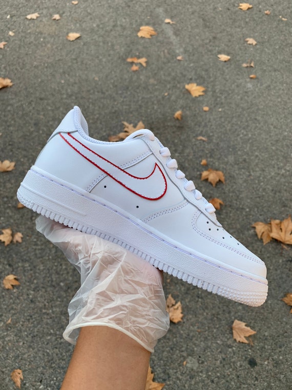 white air forces with red nike sign