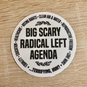 Op de afbeelding: Een witte, ronde sticker met zwarte tekst. De centrale tekst luidt "BIG SCARY RADICAL LEFT AGENDA", omringd door zinnen als "VOTING RIGHTS" en "REPRODUCTIVE FREEDOM". De zin "...TERRIFYING, HUH?" staat onderaan.