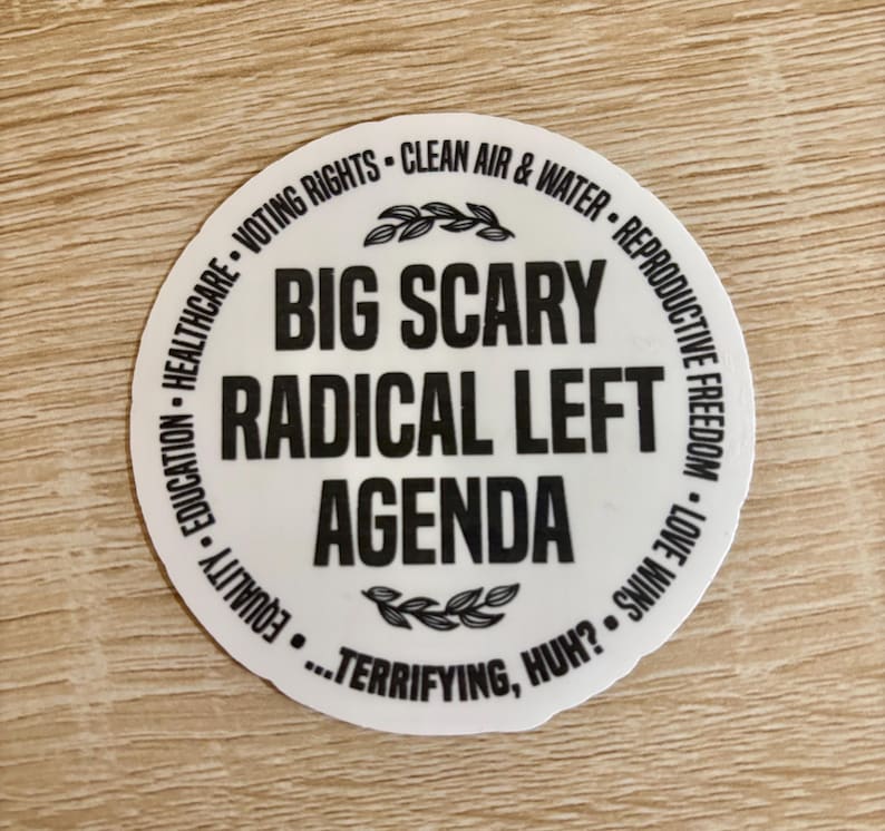 Op de afbeelding: Een witte, ronde sticker met zwarte tekst. De centrale tekst luidt "BIG SCARY RADICAL LEFT AGENDA", omringd door zinnen als "VOTING RIGHTS" en "REPRODUCTIVE FREEDOM". De zin "...TERRIFYING, HUH?" staat onderaan.
