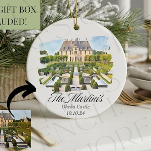 May include: White ceramic ornament with a watercolor image of a castle and formal gardens. The ornament has a gold string for hanging and includes the text "The Martinis, Oheka Castle, 10.10.24."