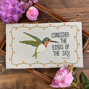 May include: Cross-stitch embroidery on linen fabric with a green hummingbird and the text "Consider the birds of the sky" with the scripture reference "Matt. 6:26".