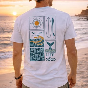 Pu&ograve; includere: Una t-shirt bianca a maniche corte con una grafica sul retro composta da quattro pannelli rettangolari contenenti un sole, una tavola da surf con pagaia, onde oceaniche con uccelli e una coda di balena, con il testo LIFE IS GOOD stampato.