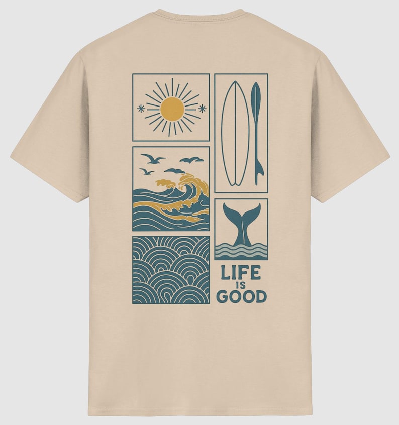 Pu&ograve; includere: Una t-shirt beige a maniche corte con una grafica a pi&ugrave; pannelli sul retro. Il design include un sole, onde oceaniche con uccelli, una tavola da surf, una coda di balena e un motivo a onde, con il testo "LIFE IS GOOD" stampato in blu scuro.