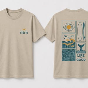 Pu&ograve; includere: Una t-shirt beige a maniche corte con una piccola grafica di un sole e onde sul petto sinistro. Il retro mostra una grande griglia rettangolare contenente un sole, una tavola da surf, onde oceaniche, uccelli e una coda di balena con il testo LIFE IS GOOD.