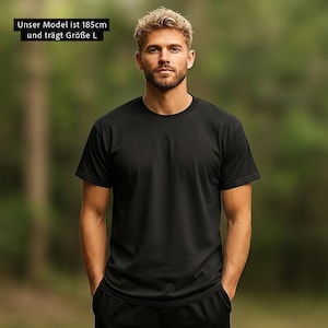 Pu&ograve; includere: Una t-shirt nera a tinta unita con maniche corte e scollo rotondo. Il capo &egrave; indossato da una persona alta 185 cm che veste una taglia L. La maglietta presenta un design semplice e pulito, privo di motivi, loghi o decorazioni visibili.