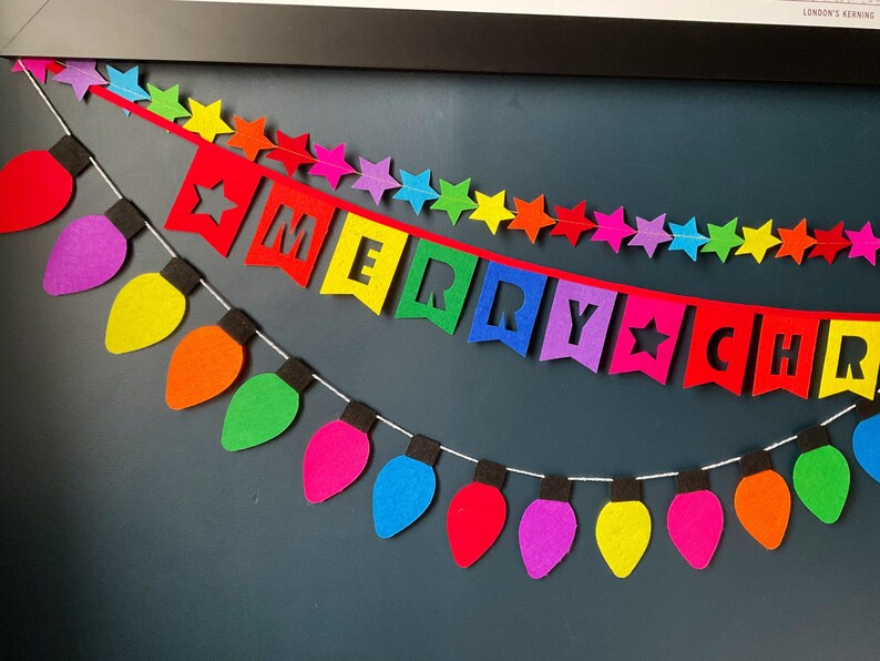 May include: A colorful felt garland with light bulbs and stars, spelling out "Merry Christmas".