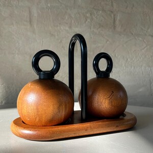 Close-up of teak spherical Bodum Ballboy salt and pepper grinders with cast iron handles, showing wood grain and vintage patina.
