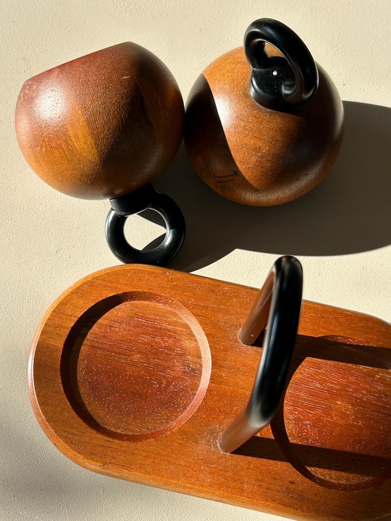 Vintage Bodum Ballboy salt and pepper mills resting on original teak stand with black metal handle, Danish modern kitchenware.