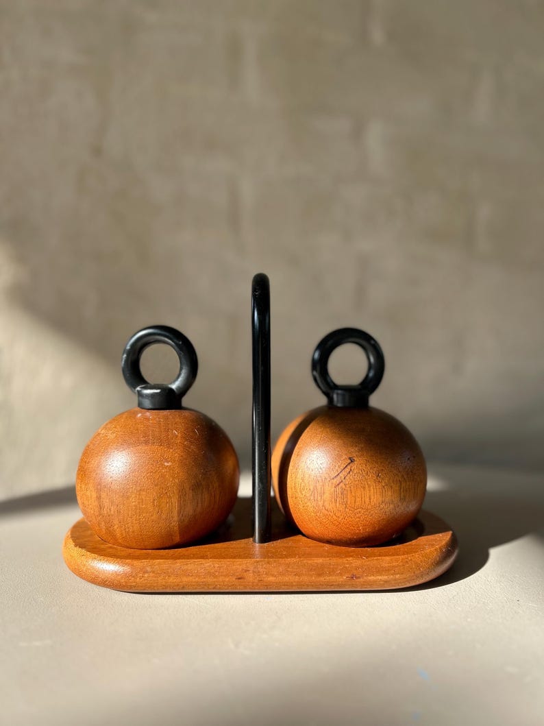 Vintage Bodum “Ballboy” salt and pepper grinders in teak with cast iron loop handles on teak stand, designed by R. Nissen, Made in Denmark.