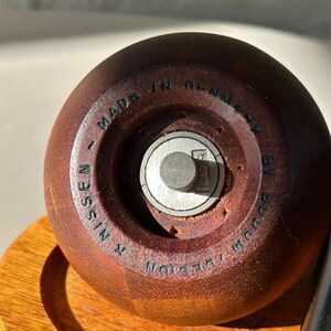 Close-up of base showing “Design R. Nissen Made in Denmark by Bodum” marking on vintage teak grinder.