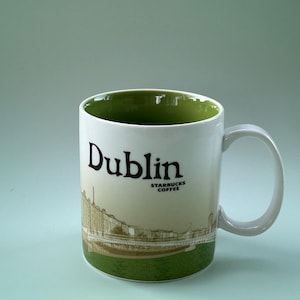 May include: White ceramic mug with a green interior and base, featuring the word "Dublin" in black script. The mug has a scenic illustration of Dublin and the Starbucks Coffee logo.
