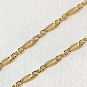 Könnte beinhalten: Eine goldene Kettenkette mit einem klassischen Figaro-Kettenmuster. Die Kette besteht aus miteinander verbundenen ovalen und runden Formen.