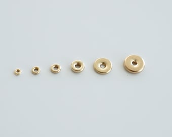 May include: A set of six gold-toned metal jump rings of varying sizes. The rings are arranged in order of size, from smallest to largest.