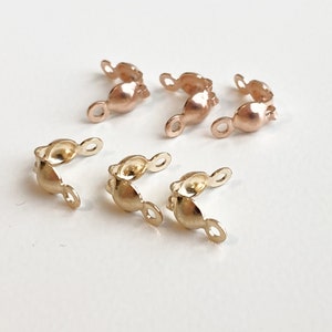 May include: A set of gold and rose gold metal clasps for jewellery making. The clasps are designed to be used with necklaces, bracelets, or other jewellery pieces.