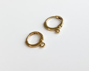 May include: Two gold-toned hoop earrings with a small jump ring attached to each hoop.