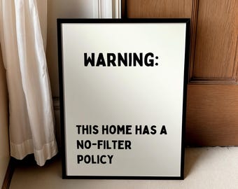 May include: Black and white framed print with the text "WARNING: THIS HOME HAS A NO-FILTER POLICY".