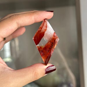 May include: A white ceramic mug with a black handle and the text "But First, Coffee" in a black, handwritten-style font. The mug is on a white surface.