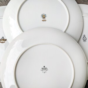 May include: Four white ceramic plates with gold trim and different logos. The logos include "Mikasa, Fine China, My Love", "Made in Japan", "Fine China", and "Made in Japan".