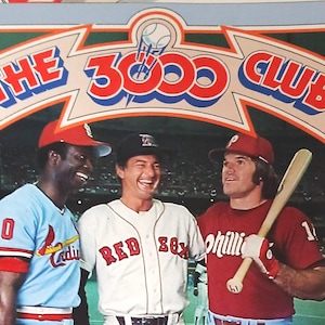 May include: Image of three baseball players in vintage uniforms. The text "THE 3000 CLUB" is displayed above them. The players are wearing jerseys with the numbers 20 and 1, and the words "Cardinals", "Red Sox", and "Phillies".