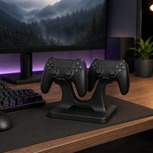 May include: A black dual controller charging dock station holding two matching black wireless game controllers. The stand features a curved, ergonomic design with a stable base, specifically shaped to cradle the controllers securely in an upright position.