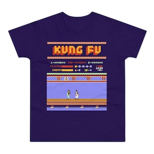 Może przedstawiać: Fioletowy T-shirt z pikselowym obrazem gry wideo Kung Fu. Ekran gry wyświetla tekst "KUNG FU", a wynik to 1-004200, TOP-004200, 2-000000. Gracz jest na 4-2-0, a czas to 1238-A-.