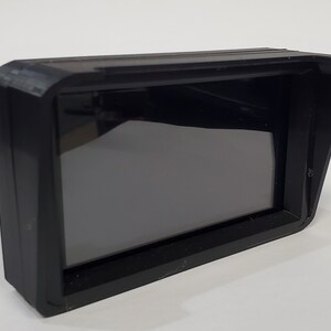 May include: A black plastic monitor with a sunshade. The monitor has a black screen and a rectangular shape.