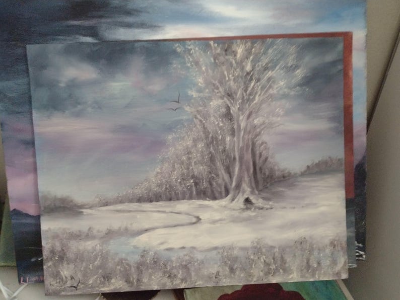 K&ouml;nnte beinhalten: &Ouml;lgem&auml;lde einer Winterlandschaft mit einem gro&szlig;en, schneebedeckten Baum als Mittelpunkt. Das Kunstwerk zeigt einen gewundenen Pfad durch ein schneebedecktes Feld unter einem bew&ouml;lkten Himmel, mit zwei V&ouml;geln im Flug. Die Farbpalette wird von Wei&szlig;, Grau und Lila dominiert.