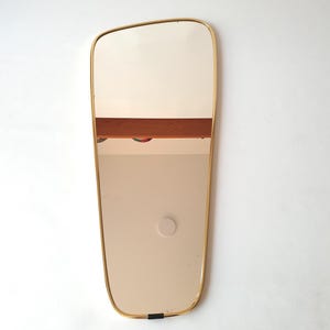 Large wall mirror made by Lenzgold Germany in the 1960s with a tapered brass frame and original hanging cord and clips.