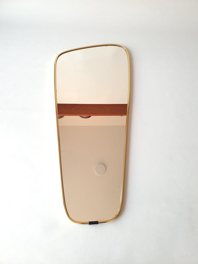 Large wall mirror made by Lenzgold Germany in the 1960s with a tapered brass frame and original hanging cord and clips.