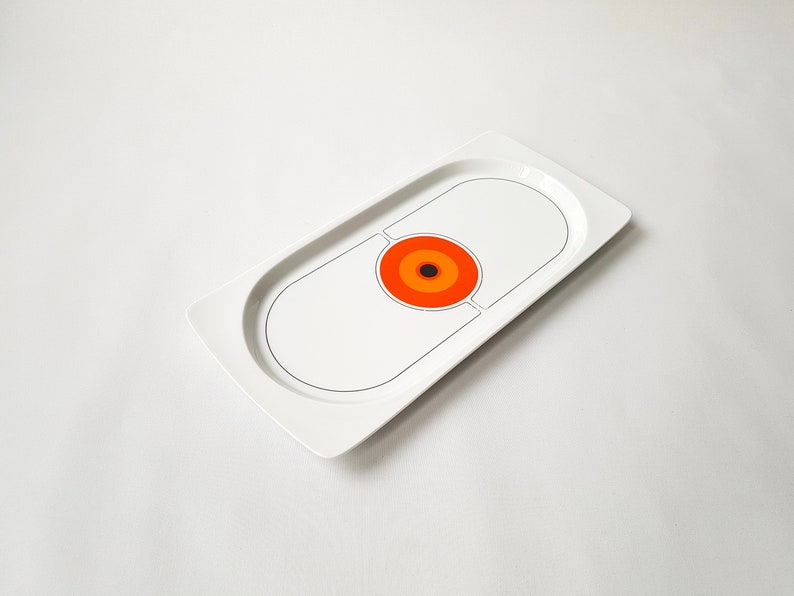 Pu&ograve; includere: Una tazza di ceramica bianca con manico nero e la scritta "But First, Coffee" in grassetto nero. La tazza &egrave; appoggiata su una superficie di legno. La tazza &egrave; alta circa 10 cm.
