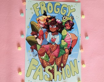 Könnte beinhalten: Ein Comic-Cover mit drei Comicfiguren. Die Figuren sind ein grüner Frosch, ein Mädchen mit braunen Haaren und einem grünen Shirt und ein Mädchen mit blonden Haaren und einem blauen Shirt. Das Comic-Cover trägt den Titel "Froggy Fashion".