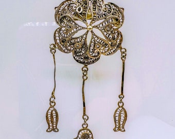 Silver vintage brooch in oriental style, made in filigree technique and decorated with Hamsa hand pendants. Years 1930-1950.