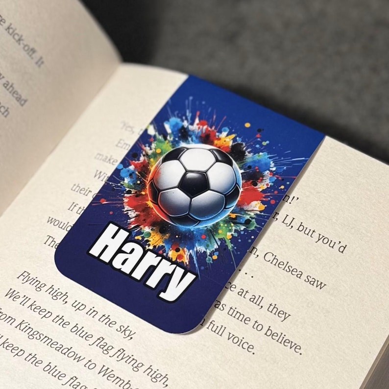 May include: A blue personalized bookmark with a colorful soccer ball graphic and the name "Harry" printed in white.