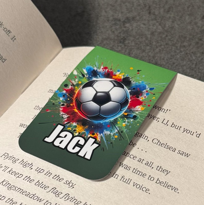 May include: Green bookmark with a colorful soccer ball graphic and the name "Jack" in white text. The background is a green watercolor splatter design.