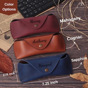 Pode incluir: Tr&ecirc;s estojos de &oacute;culos de couro nas cores mogno, conhaque e azul safira. Cada estojo &eacute; personalizado com um nome e preso com um fecho de bot&atilde;o. Os estojos medem 18,4 cm de comprimento e 7 cm de largura.
