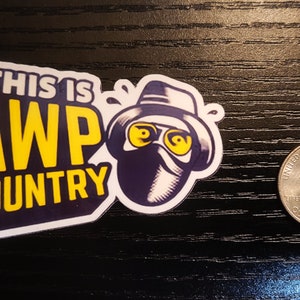 May include: A yellow and blue sticker with the text "This is AWP Country" and a cartoon illustration of a person wearing a hat, sunglasses, and a mask.