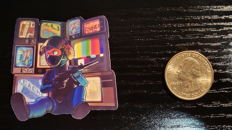 May include: A sticker featuring a cartoon character wearing a black helmet and holding a gun. The character is sitting in front of a wall of old televisions with static and other images on the screens.