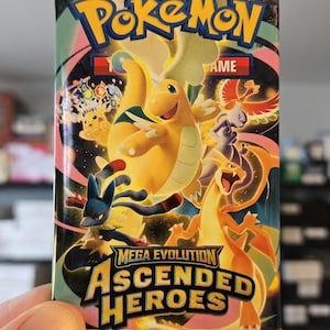 以下が含まれることがあります： 「ポケモン」と「メガ進化アセンデッドヒーローズ」の文字が入ったポケモンカードパック。黄色、オレンジ、青、赤の色合いで様々なポケモンのキャラクターが描かれたカラフルなデザイン。追加のゲームカードが10枚含まれています。