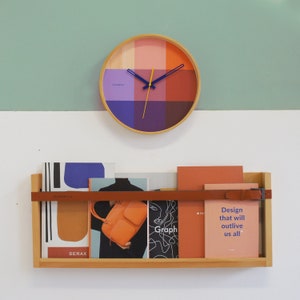 An art piece and timepiece in one. The red Flor wall clock is warm and welcoming, yet modern and minimal, all at the same time. Solid natural wood frame. Pop of color via the vibrant printed face and contrasting hands. The definition of Dutch design.