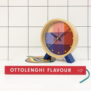 Brighten up any room with the Riso Alarm clock. Solid wood frame. Saturated graphic printed face in a mix of red and blue. An homage to the Risograph printing machine created in Japan in the 1980s. This silent clock will stand the test of time.