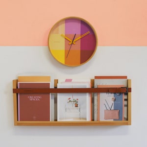 The pink and yellow riso clock pops on your wall like a trendy accent.