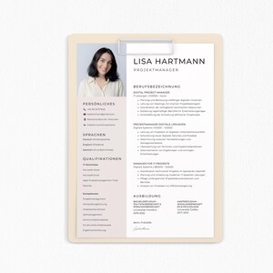 May include: A resume on a clipboard featuring a headshot of a woman and the name "Lisa Hartmann." The document includes sections for personal information, languages, qualifications, and education. The text is in black font on a light beige background.