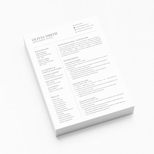 May include: A stack of white paper resumes with the name "Olivia Smith, Registered Nurse" at the top. The resume includes sections for education, licenses, skills, and experience. The text is in black font.