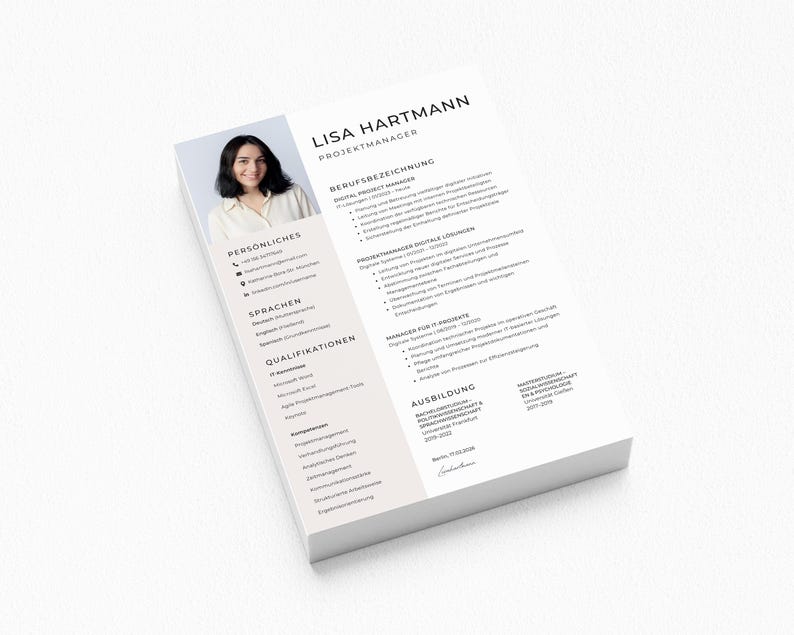 May include: A stack of white resume papers with the name "Lisa Hartmann" and the title "Projektmanager" at the top. A photo of a woman is in the upper left corner. The resume includes sections for personal information, languages, and qualifications.